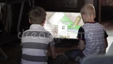 两个男孩坐在家里<strong>玩电脑</strong>游戏